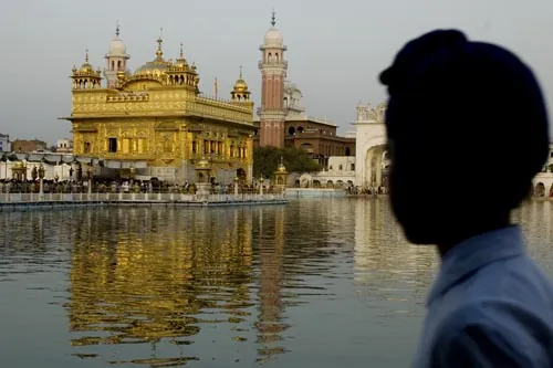 Pohľad na Zlatý chrám a silueta mladého Síkha. (Amritsar)